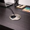 Brushed nickel round cable grommet with black cable connected to laptop on modern desk with tablet