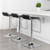 Set of three sleek Waterfall bar chairs with black seats and stainless steel bases in white kitchen