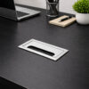 Rectangular aluminium cable grommet installed in desk