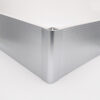 Fixed 90 degree corner connector joining ribbed silver kitchen plinths at an external cabinet corner
