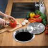 Stainless steel counter bin lid installed in kitchen countertop for easy food prep waste disposal